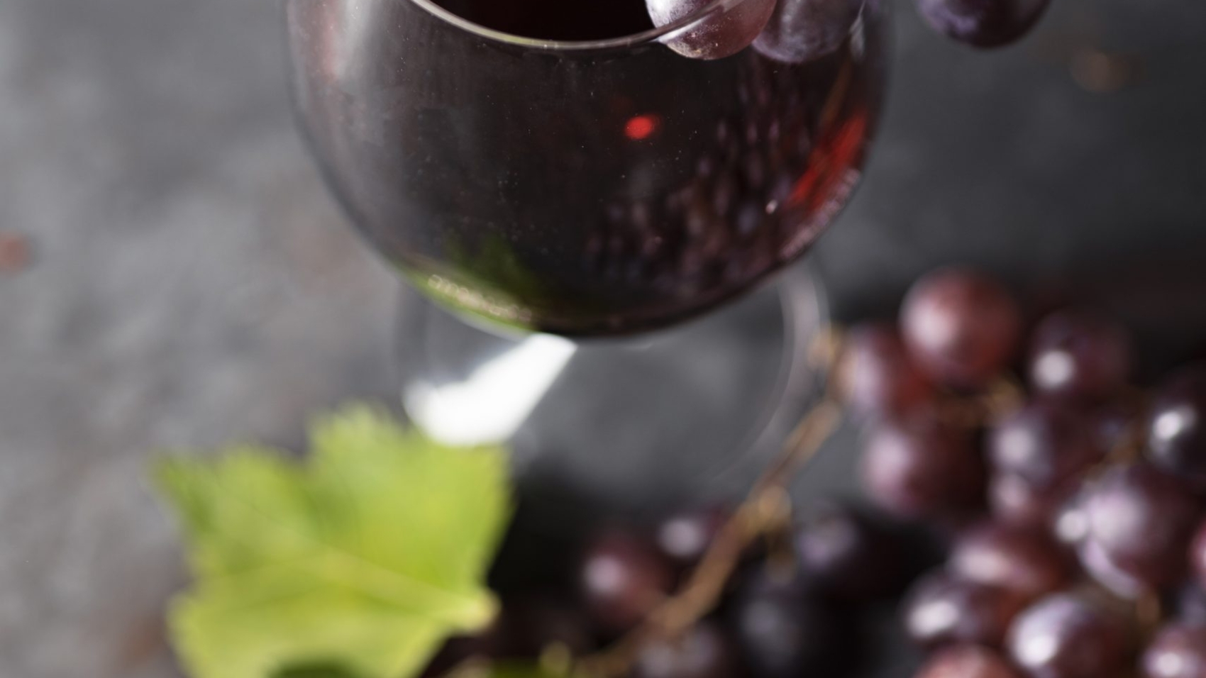 close-up-wine-glass-surrounded-by-grapes